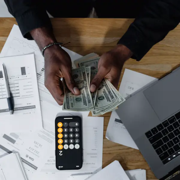 Desk with financial reports, a calculator and a laptop